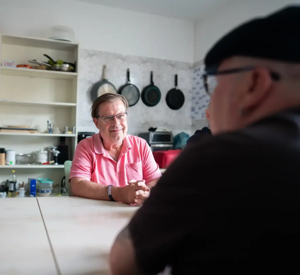 Mehrere Personen sitzen an einem Tisch und unterhalten sich.