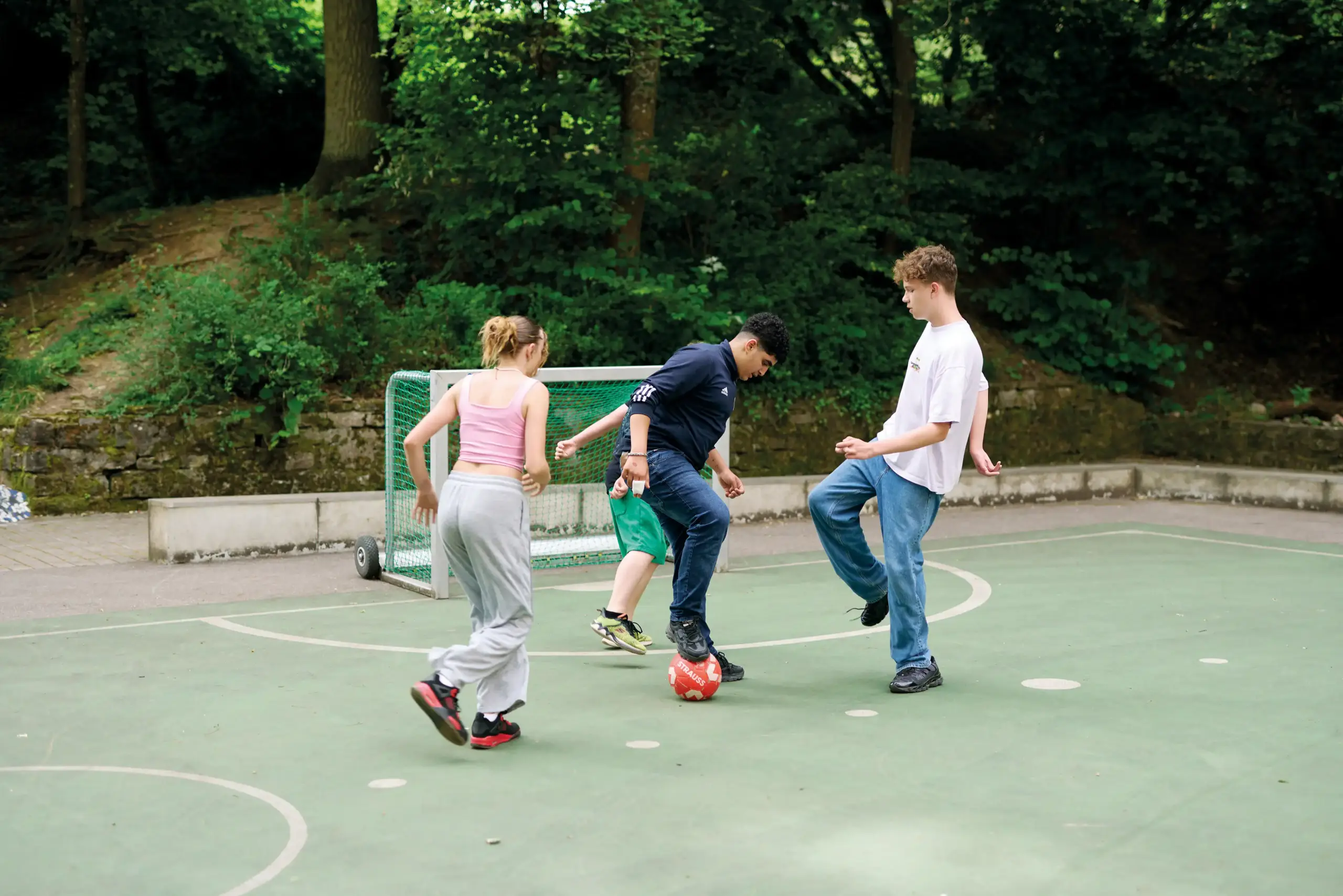 Quelle: BLV Vier Jugendliche spielen zusammen Fußball.
