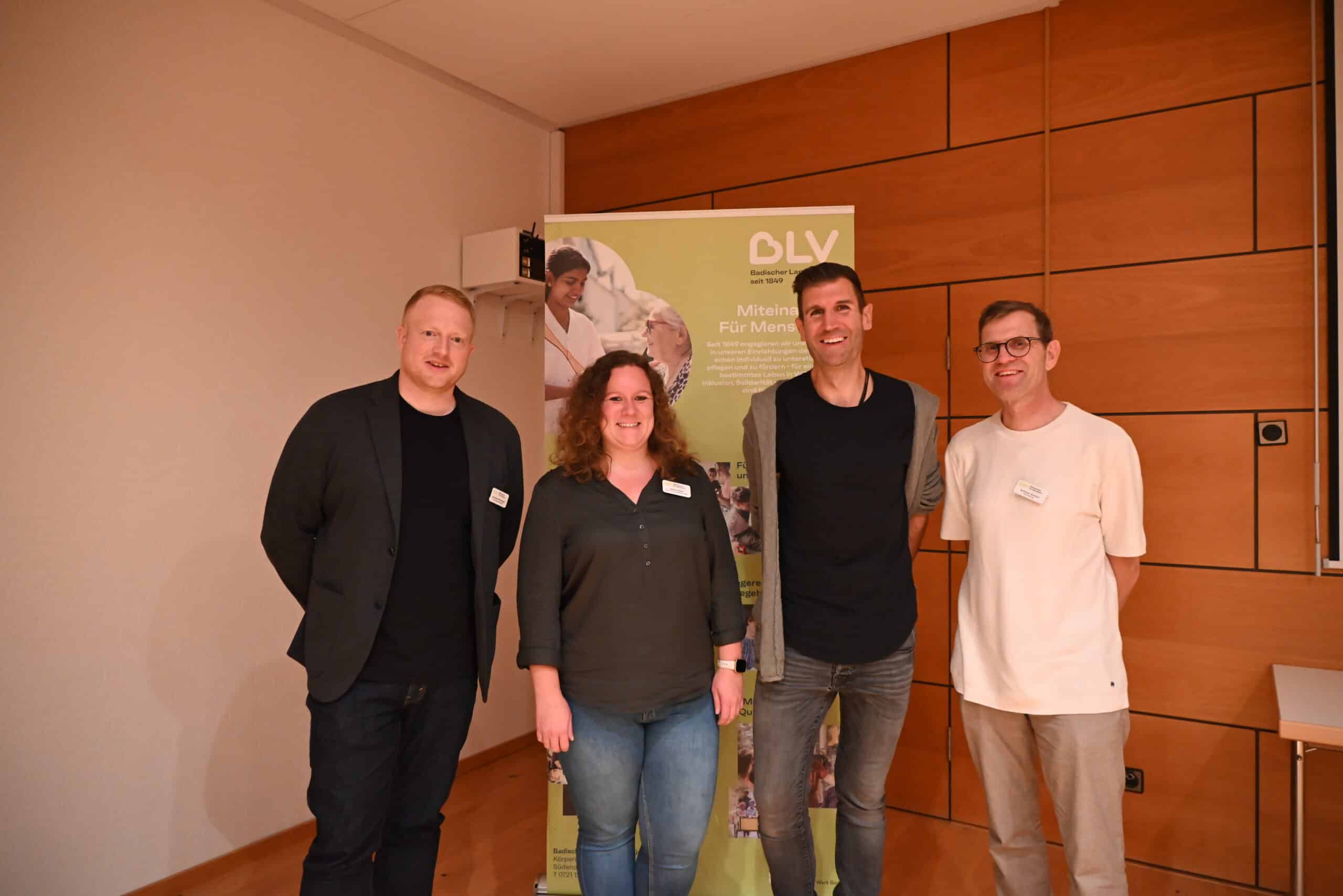 Vier Personen stehen nebeneinander, hinter ihnen ein Aufsteller mit Logo des BLV. Von links nach rechts: Christoph Röckinger (Einrichtungsleitung Hohberghaus), Jessica Seitz (stellv. Einrichtungsleitung Hohberghaus), Referent Christoph Boswyk, Andreas Gerlach (Bereichsleitung ambulante und präventive Hilfen).