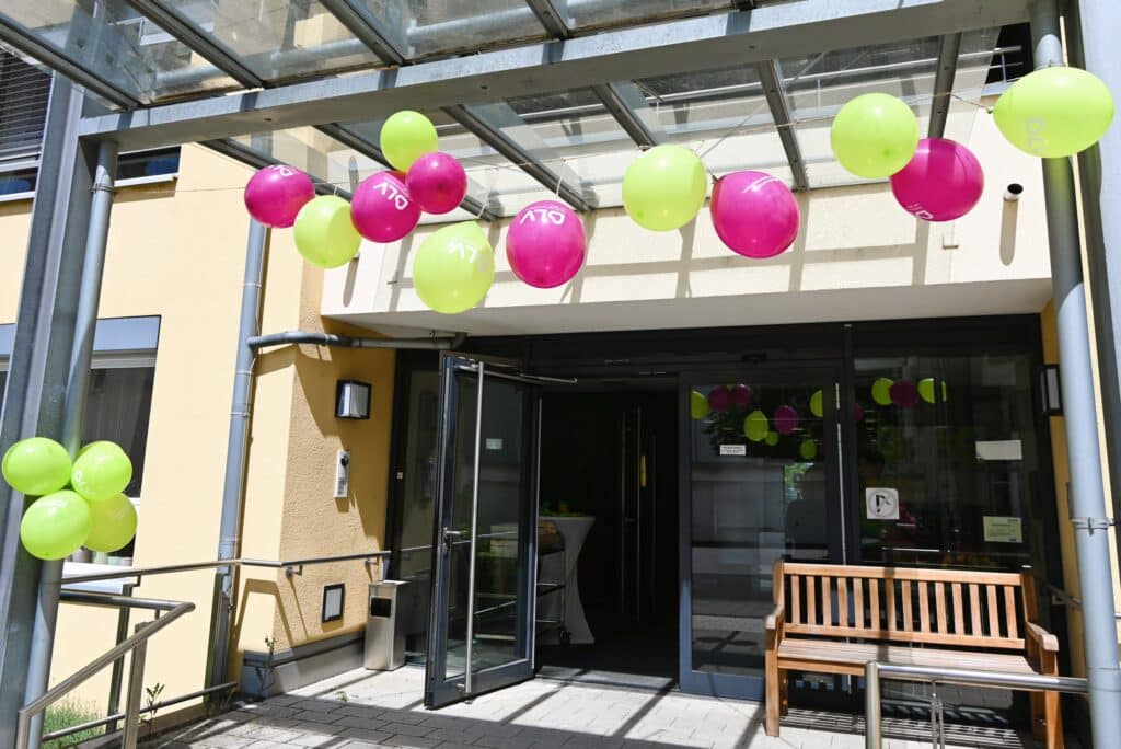 Der Eingang der Pflegeeinrichtung Haus Karlsruhe Weg ist mit grünen und lila Luftballons geschmückt