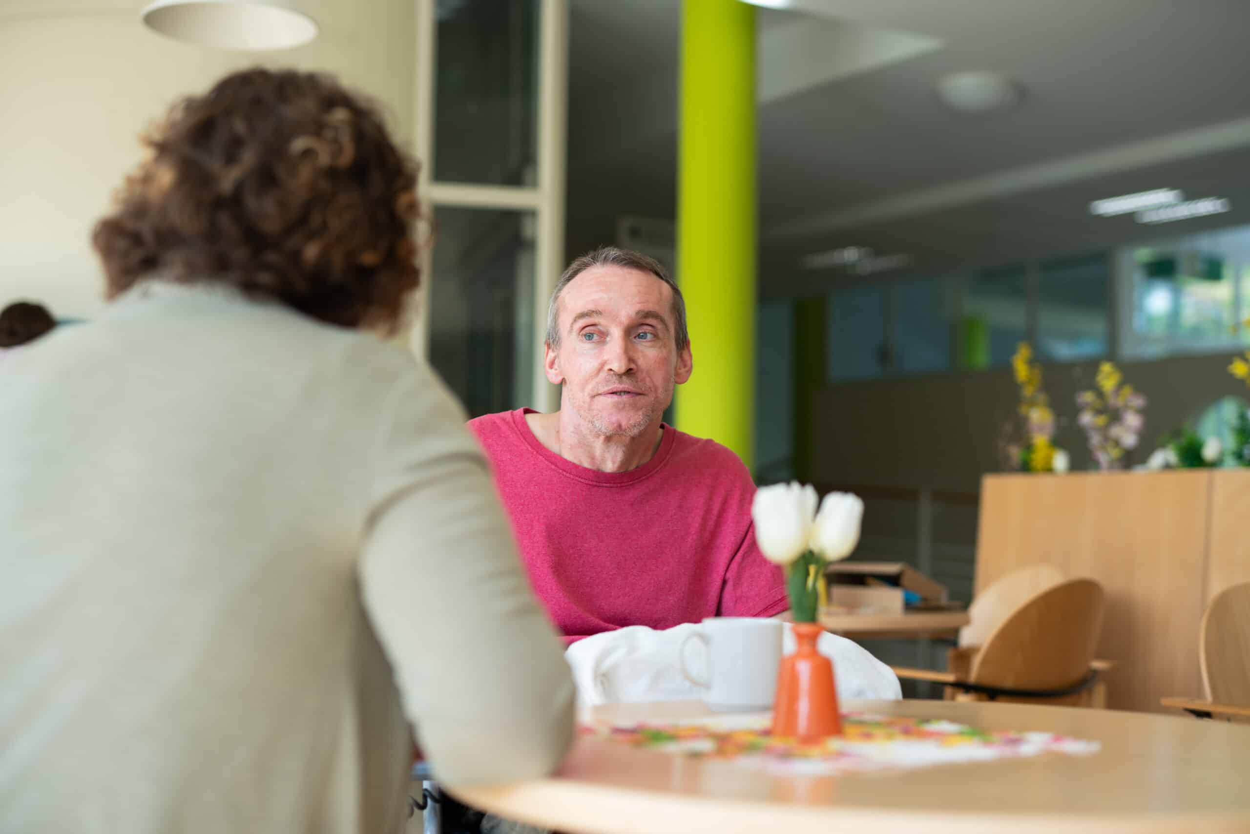 Quelle: BLV Zwei Personen sitzen an einem Tisch und sprechen miteinander.