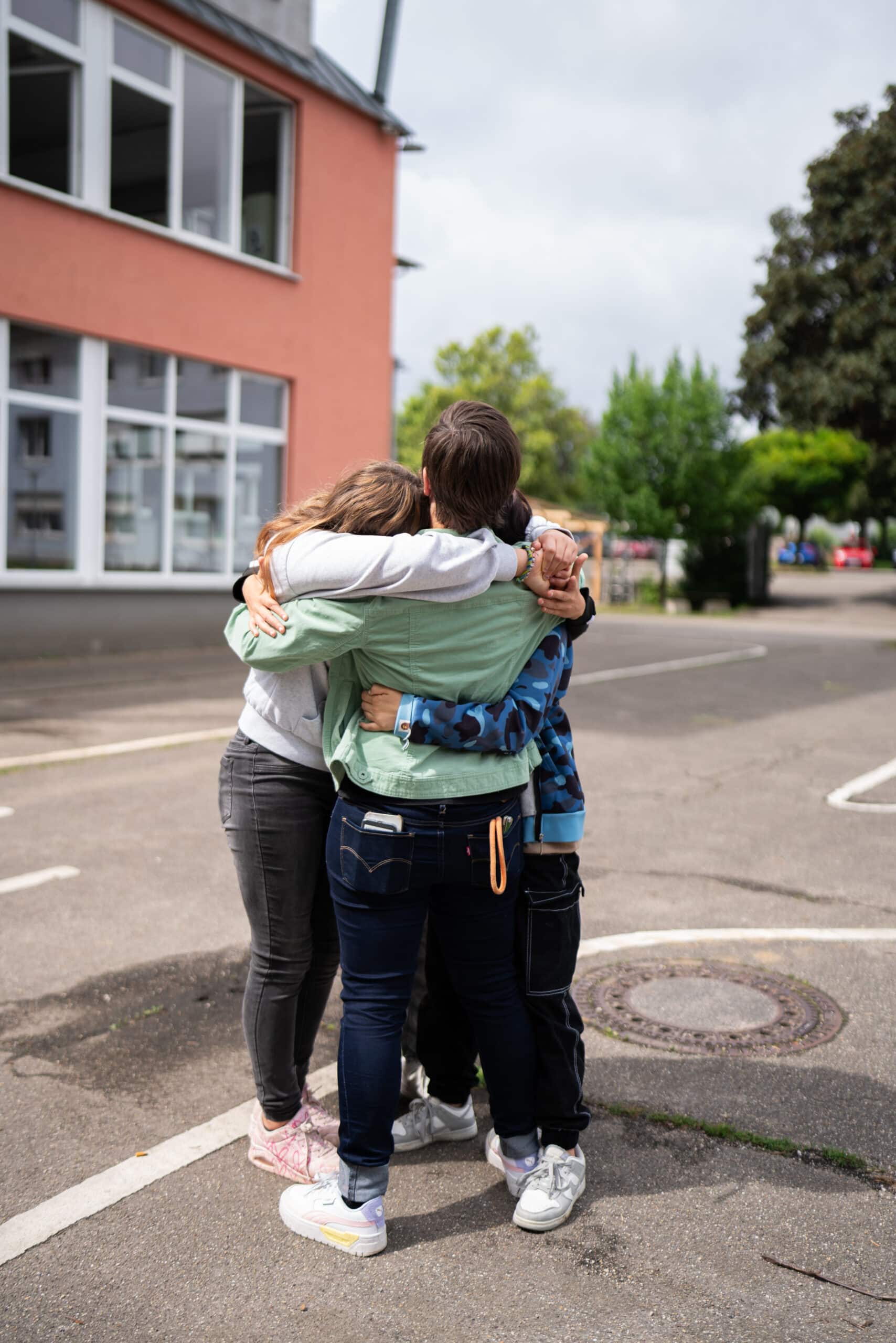Eine Frau umarmt drei Kinder.